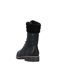 Czarne skórzane botki za kostkę, z futrzanym mankietem, okrągłym noskiem, sznurowanym przodem, teksturowaną gumową podeszwą oraz małym logiem po boku.