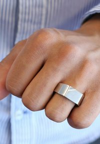 Sterling zilveren ring met een platte band, met een diagonale gestructureerde lijn. Het oppervlak is gepolijst met een subtiele matte afwerking.