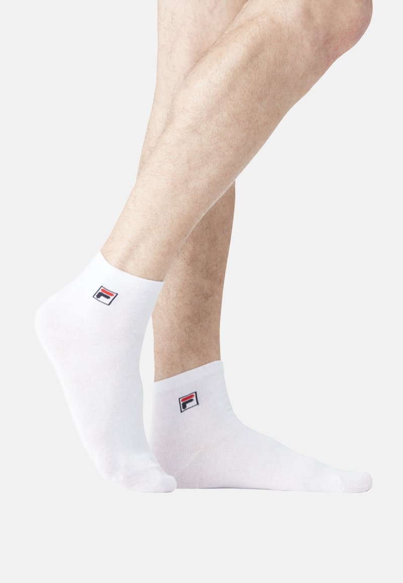 Chaussettes blanches à la cheville en mélange de coton, avec un petit logo coloré sur le côté extérieur. Texture lisse et ajustement confortable.
