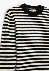 Schwarz-weißer gestreifter Ripppullover mit Rundhalsausschnitt aus strukturiertem Stoff. Horizontale Streifen variieren in der Dicke.