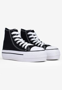 Sneaker alte nere in tela con lacci bianchi, cuciture a contrasto e una spessa suola in gomma bianca con grip texturizzato.