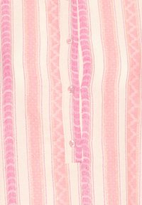 Vertikalios rausvos ir persikinės juostelės audinys su įvairiais raštais ir trys rožiniai mygtukai palei centrinį siūlę.