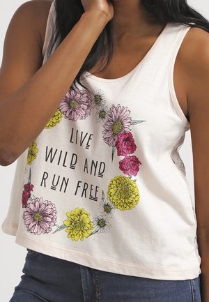 Débardeur ample de couleur rose clair avec imprimé floral et texte noir indiquant "VIVEZ SAUVAGE ET COUREZ LIBREMENT." Matière en mélange de coton, design décontracté.