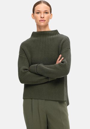 Olive green, ribbed knit sweater with a high neck and loose fit. Features dropped shoulders and long sleeves, made from textured material.