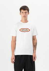 Hvid bomulds t-shirt med et multicolor "RIPCURL" logo i en fed retrostil, med korte ærmer og rund halsudskæring. Struktureret stof.