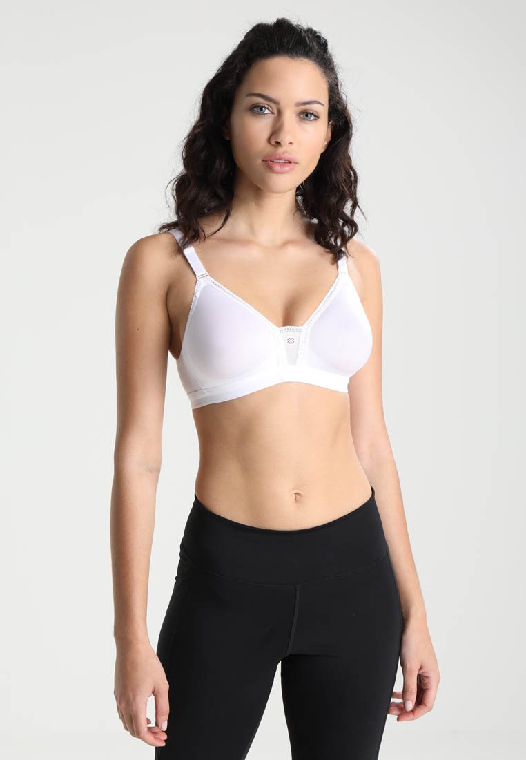 Hvit trådløs BH med trekantede kopper, blondekant i midten, justerbare stropper og glatt tekstur; kombinert med svarte høyhals leggings.