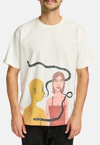 White cotton t-shirt featuring a graphic print of two figures, one yellow and one pink, with black text and a snake-like design.