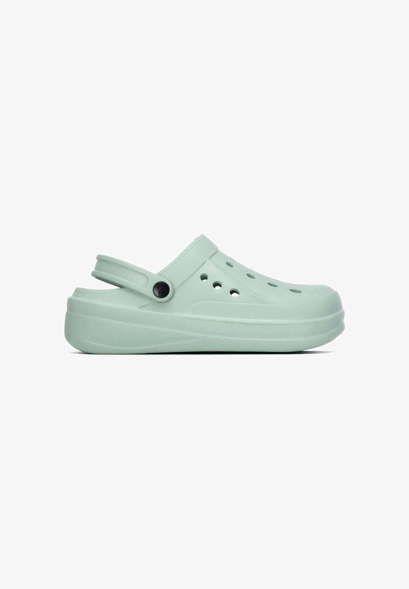 Sabot vert clair à enfiler avec bride arrière réglable et trous de ventilation sur le dessus et sur le côté.