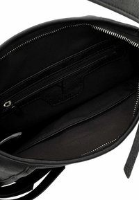 Musta nahkalaukku, jossa on sileä tekstuuri ja vetoketjullinen sisätasku. Sisätilassa on kangaspäällyste ja järjestetty layout.