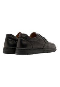 Scarpe in pelle nera con finitura liscia, punta rotonda e suola in gomma bassa. Dettagli dei lacci e delle cuciture nella parte anteriore e laterale.