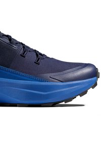 Herenhardloopschoen met een marineblauwe bovenkant van textuurstof, blauwe tussenzool en een robuuste zwarte buitenzool voor grip. Beveiligd vetersysteem.