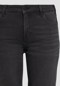 Schwarze Denim-Jeans mit schlanker Passform, subtilen Glitzerakzenten an der Vordertasche und klassischem Knopfverschluss. Strukturiert.
