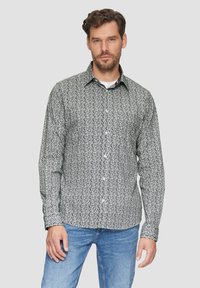 Schwarz-weißer karierter Button-Up-Hemd mit Kentkragen, schlanker Schnitt und langen Ärmeln, kombiniert mit blauen Jeans.