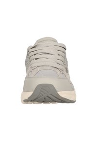 Hellgraue Sportschuhe mit strukturiertem Obermaterial, Schnürung und einer kontrastierenden weißen Zwischensohle sowie einer geriffelten Gummisohle.