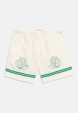 Fehér elasztikus rövidnadrág zöld csíkokkal a szegély közelében és mosolygó virág hímzéssel mindkét lábrészen, húzózsinóros derékkal.