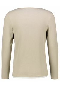 Top beige a maniche lunghe con un design testurizzato a costine e scollatura rotonda. Presenta un orlo dritto ed è realizzato in un tessuto leggero.