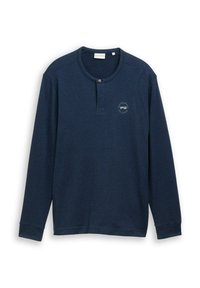 Marineblaues Langarm-Henley-Shirt mit einem Knopf am runden Ausschnitt und kleinem, kreisförmigen Textdruck auf der linken Brust.