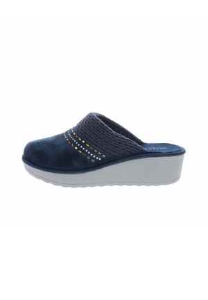 Zapatilla azul marino de punta cerrada, con una tira de tela acanalada, tachuelas doradas y plateadas y una suela gruesa de color gris claro.