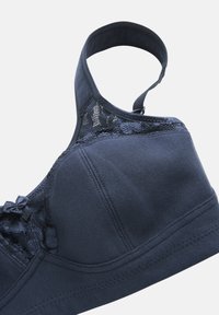 Marinblå bh med en slät tyg, spetsdetaljer och en dekorativ rosett. Har en strukturerad kupa, justerbara remmar och sömlösa kanter.