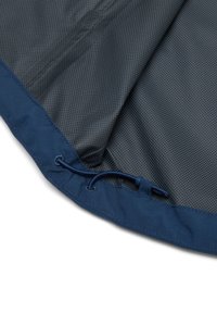 Borde de tela azul marino con cordón ajustable y forro interior de patrón cuadriculado gris, doblado para mostrar textura y detalles de costura.