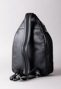 Black leather backpack with a smooth texture, featuring dual zippers, adjustable straps, and a distinct triangular shape.