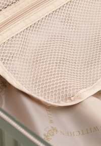 Beige Netzfach mit Reißverschluss in einer hellgrünen Tasche, ausgekleidet mit Stoff, bedruckt mit "WITTCHEN" und einem Wappen-Logo.