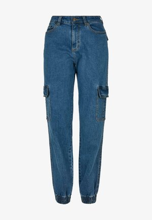 Džínsy cargo v stredne modrej farbe s elastickými manžetami, dvoma bočnými vreckami a dvoma vreckami na stehnách s klopňami. Klasické prešívacie detaily.