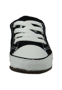 Baskets en toile noires avec lacets blancs, capuchon en caoutchouc à l'avant et semelle blanche texturée. Présente des coutures contrastées le long des bords.