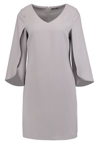 Grå klänning med V-ringning, klockärmar och dragkedja i ryggen. Tillverkad av slät tyg, vilket ger en minimalistisk silhuett.