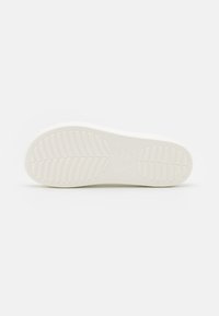 Semelle de chaussure en caoutchouc blanc avec un motif texturé, présentant des rainures de semelle plus larges et le logo de la marque en relief. Fini lisse, sans signe d'usure visible.