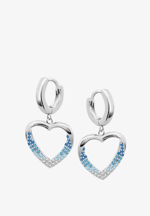 Boucles d'oreilles en argent avec des pendentifs en forme de cœur. Ornées de pierres précieuses bleues en dégradé et transparentes, mettant en valeur une texture scintillante.