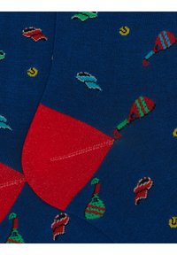 Calzini lavorati a maglia con una base blu scuro, caratterizzati da motivi colorati di maracas e forme giocose. Accenti in rilievo di colore rosso su tacco e punta.