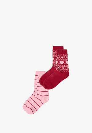 Conjunto de calcetines rojos y rosas; uno con un patrón de corazones y diseño fair isle, el otro con rayas rojas horizontales sobre un fondo rosa.