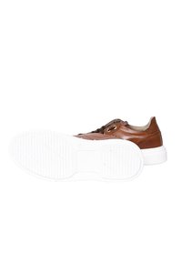 Sneaker in pelle marrone con suola in gomma bianca, caratterizzato da un design con lacci, punta rotonda e dettagli di cucitura discreti. Texture liscia nel complesso.