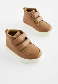 Baskets montantes en simili cuir marron avec deux bandes Velcro, doublure en tan peluche et semelles en caoutchouc blanc. Pas de motifs ou d'accents visibles.