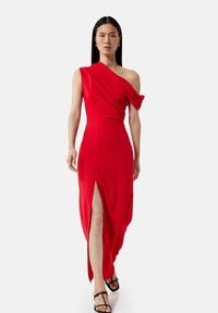 Rotes Ein-Schulter-Kleid mit drapiertem Stoff, seitlichem Schlitz bis zum Oberschenkel und schmaler Taille. Hat eine glatte, weiche Textur und eine elegante Silhouette.
