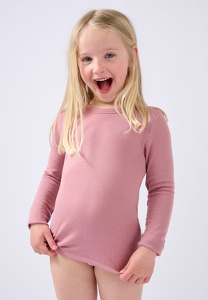 Maglietta a maniche lunghe in morbido cotone rosa chiaro con scollatura a girocollo, caratterizzata da un design aderente e una superficie liscia, indossata da un bambino che tiene il fondo.