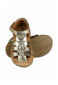 Sandales métalliques dorées avec des lanières tissées, doublure en cuir couleur tan et semelle en caoutchouc texturée avec un motif en zigzag. Taille 22 indiquée.