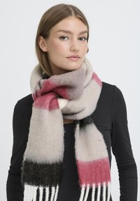 Multifarvet tørklæde i blød, fuzzy uldblanding. Har gradientnuancer af grå, pink og sort med frynse-accenter i enderne.