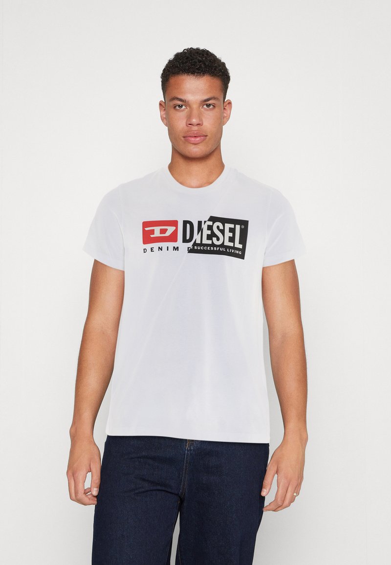 Camiseta de algodón blanca con un gran logo de Diesel en negro y rojo que incluye el texto "DENIM" y "SUCCESSFUL LIVING". Diseño de mangas cortas y cuello redondo.