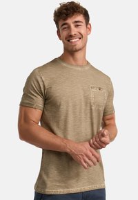 Oliven grøn kortærmet t-shirt lavet af struktureret stof med en brystlomme med knap. Casual pasform og rund halsudskæring.