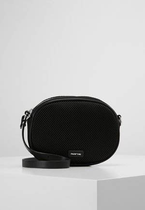 Sac bandoulière en maille noire d'une forme arrondie, avec des détails lisses, une fermeture éclair et une sangle réglable. Logo affiché à l'avant.