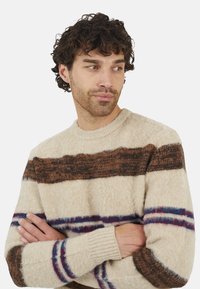 Getextureerde crèmekleurige trui met horizontale strepen in bruin, rood en blauw. Voorzien van een ronde hals en ribgebreide boorden voor extra detail.