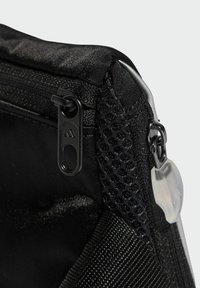 Čierna textilná taška s hladkou textúrou, vybavená čiernym zipsom s označeným ťaháčikom a sieťovaným vreckom na boku.