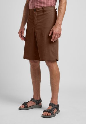 Bruine knielange shorts van lichtgewicht stof, met een knoopsluiting, riemlussen en een comfortabele pasvorm. Gecombineerd met sandalen met bandjes.