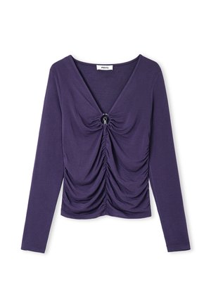 Haut violet à manches longues avec un décolleté en V profond, des détails froncés à l'avant et un accent circulaire au centre. Texture de tissu douce.