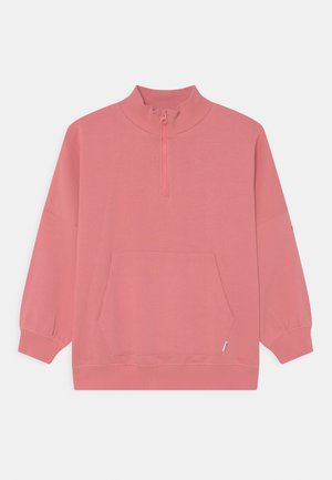 Jasnoróżowy sweatshirt z wysokim kołnierzem, pół-zamkiem, długimi rękawami i kieszenią z przodu. Materiał wydaje się miękki i gładki w dotyku.