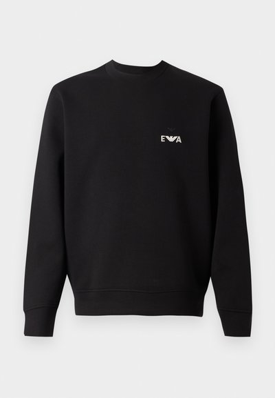 Sweat à capuche noir avec un col rond, des manches longues et des poignets côtelés. Présente un petit logo blanc brodé sur la poitrine. Matière en mélange de coton.