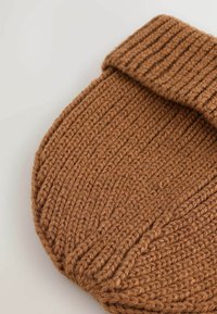 Beanie tricotat maro cu textură canelată și tiv pliat. Fabricat din fire groase pentru căldură, cu o formă rotundă și un design fără cusături.