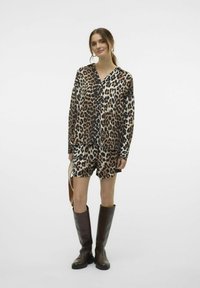 Sada trička a šortek s leopardím vzorem v odstínech hnědé a černé, doplněná vysokými hnědými kozačkami. Měkký materiál a uvolněný střih.